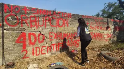 Familias de desaparecidos pintan barda de panteón en Jojutla exigiendo plan integral de exhumaciones